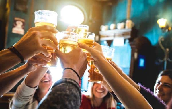 Friends Drinking Toasting Beer At Bar